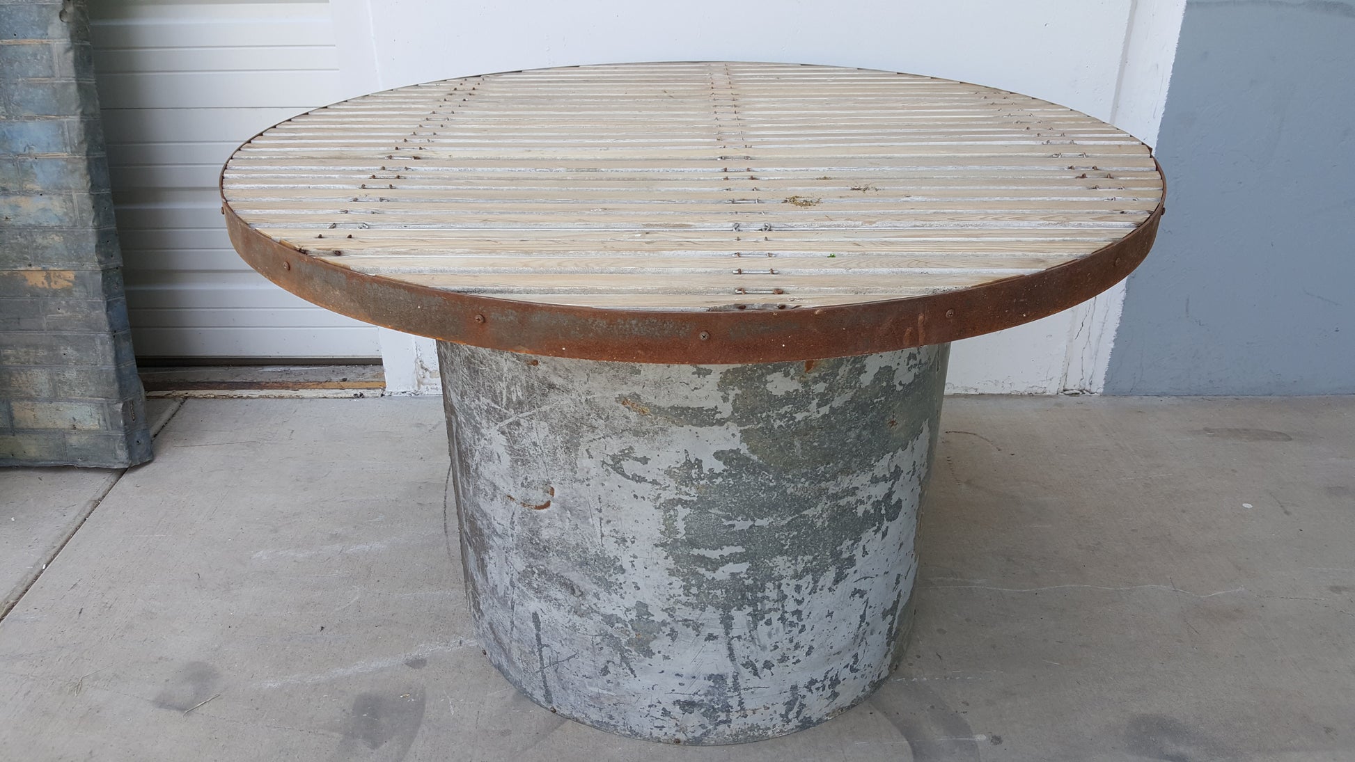 High table with metal base and aged wood top